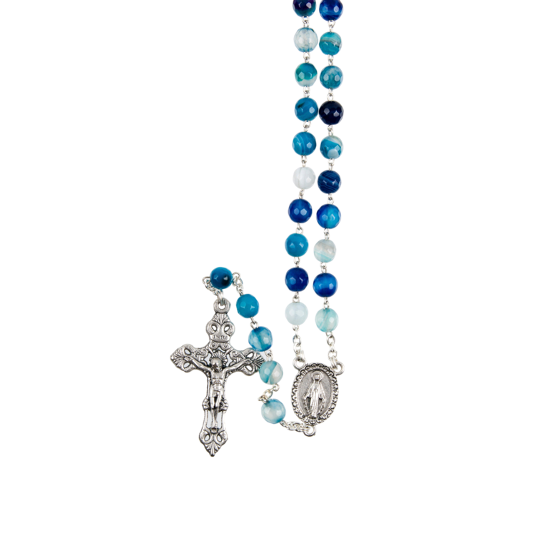Chapelet grains agate bleue, Ø 7 mm, chaîne couleur argentée, longueur au cœur 32 cm, croix avec Christ. Livré en boîte.