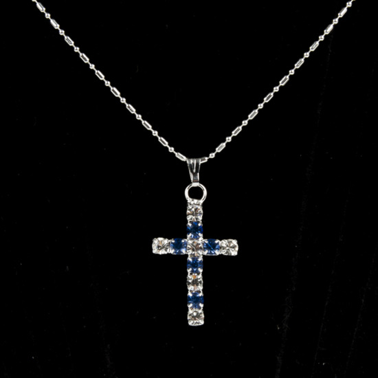 Collier avec chaîne couleur argentée L.45 cm, croix en zirconium couleur assortie H. 2,7 cm.